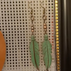 Turquoise colored feather earrings.